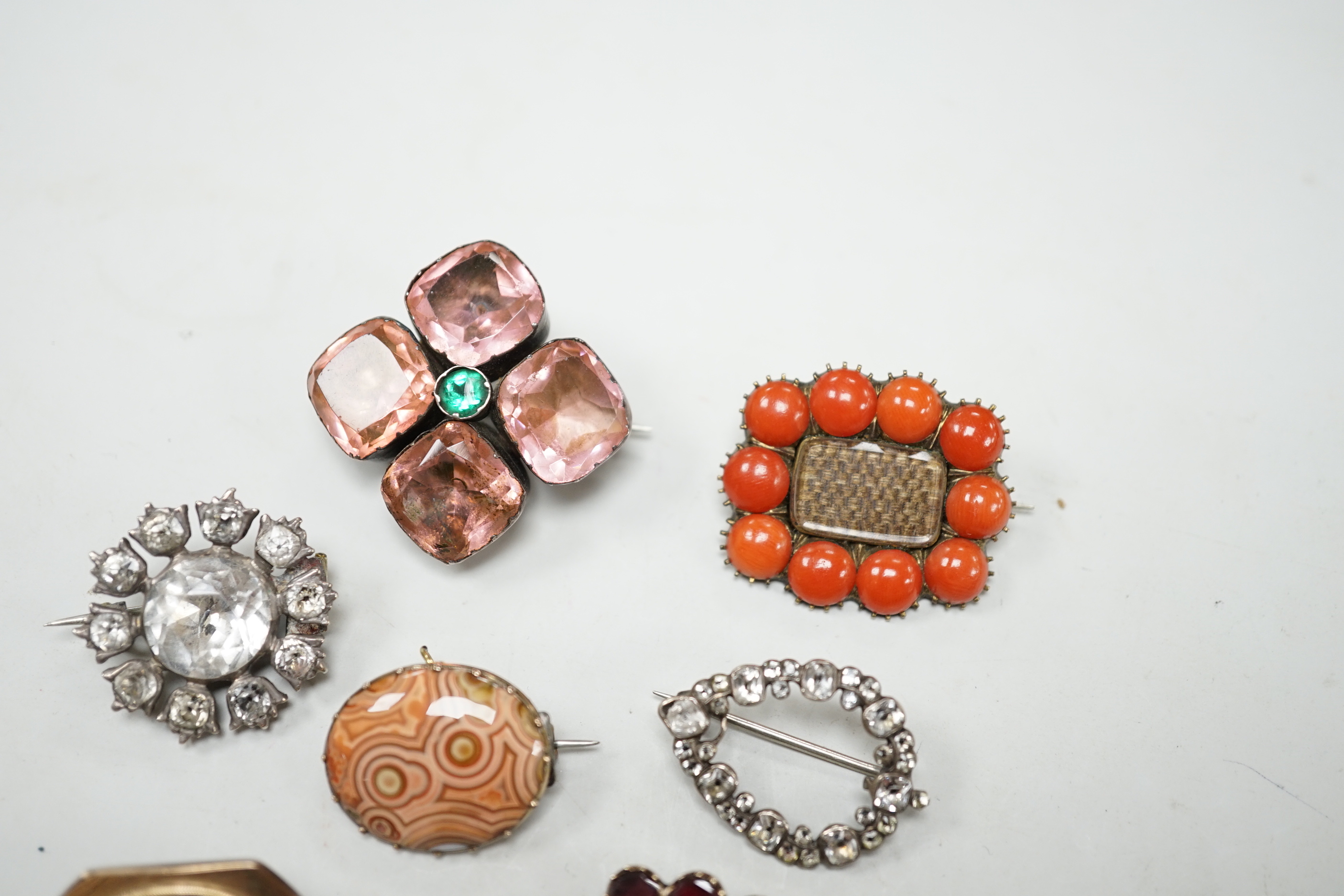 Eight assorted mainly 19th century items of jewellery, including four paste set brooches, garnet, seed pearl and plaited hair mourning brooch, a similar coral and plaited hair brooch and two chalcedony set brooches.
